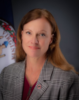 Foto de la subsecretaria Leah Mills con el sello de la Commonwealth en el fondo